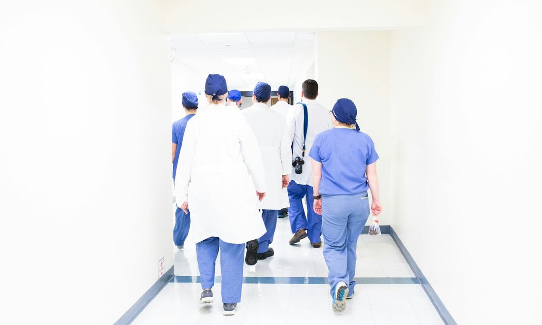 Une équipe médicale en tour de salle dans un couloir d'hôpital