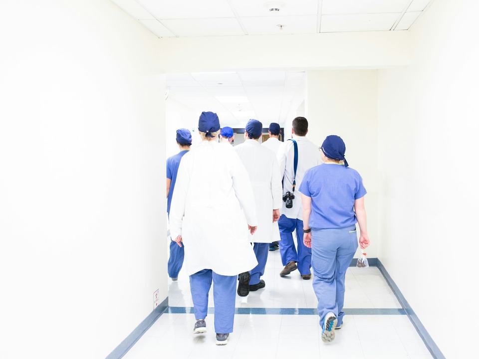 Une équipe médicale en tour de salle dans un couloir d'hôpital